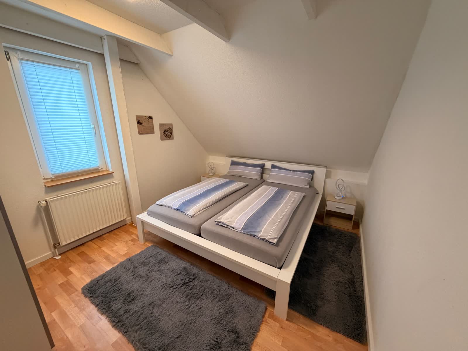 Schlafzimmer mit Doppelbett 180 cm, Nachttischen und Fenster